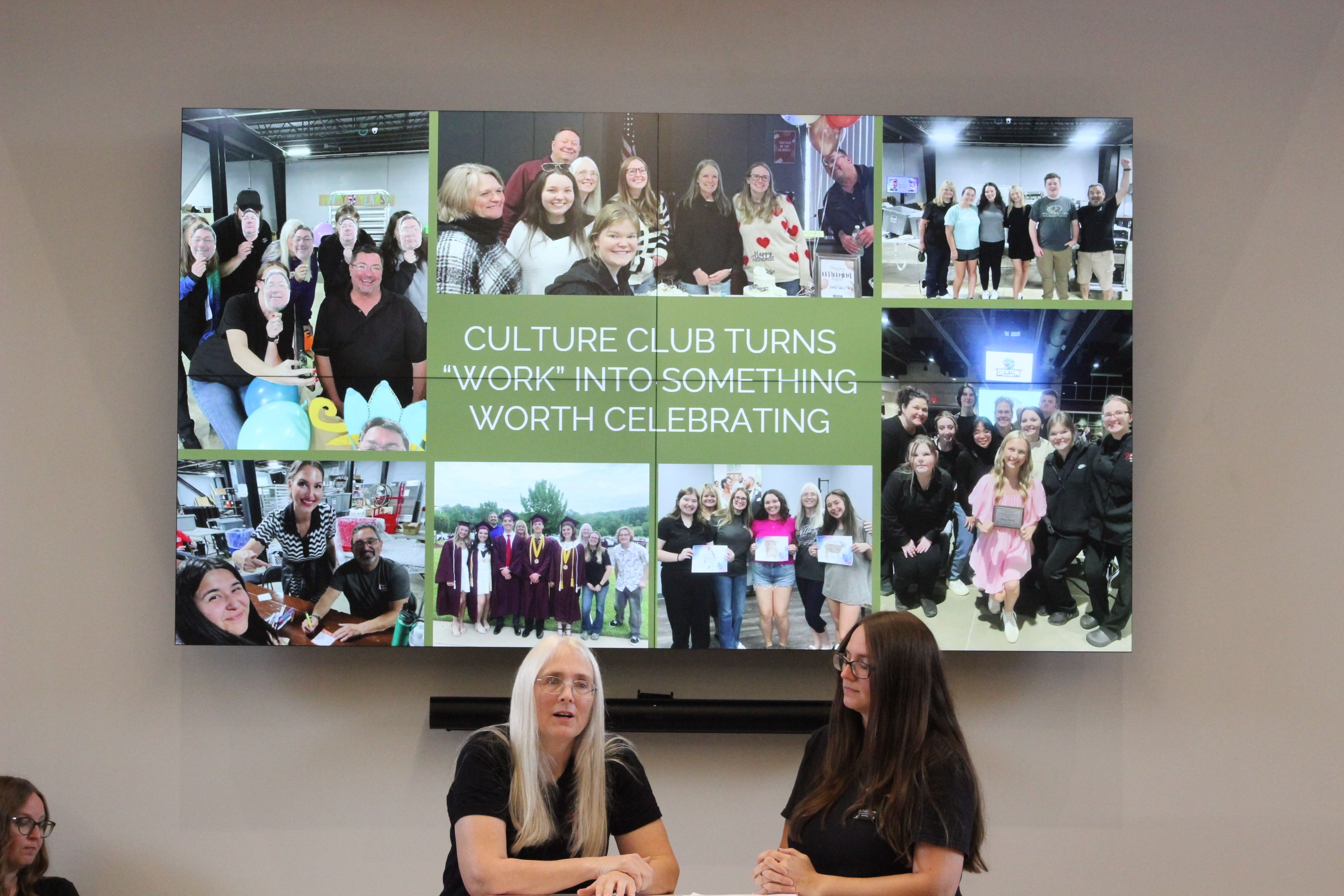 Learn How to Increase Company Culture Two women sit at a table in front of a screen displaying a collage of group photos. The screen text reads, Culture Club turns work into something worth celebrating.