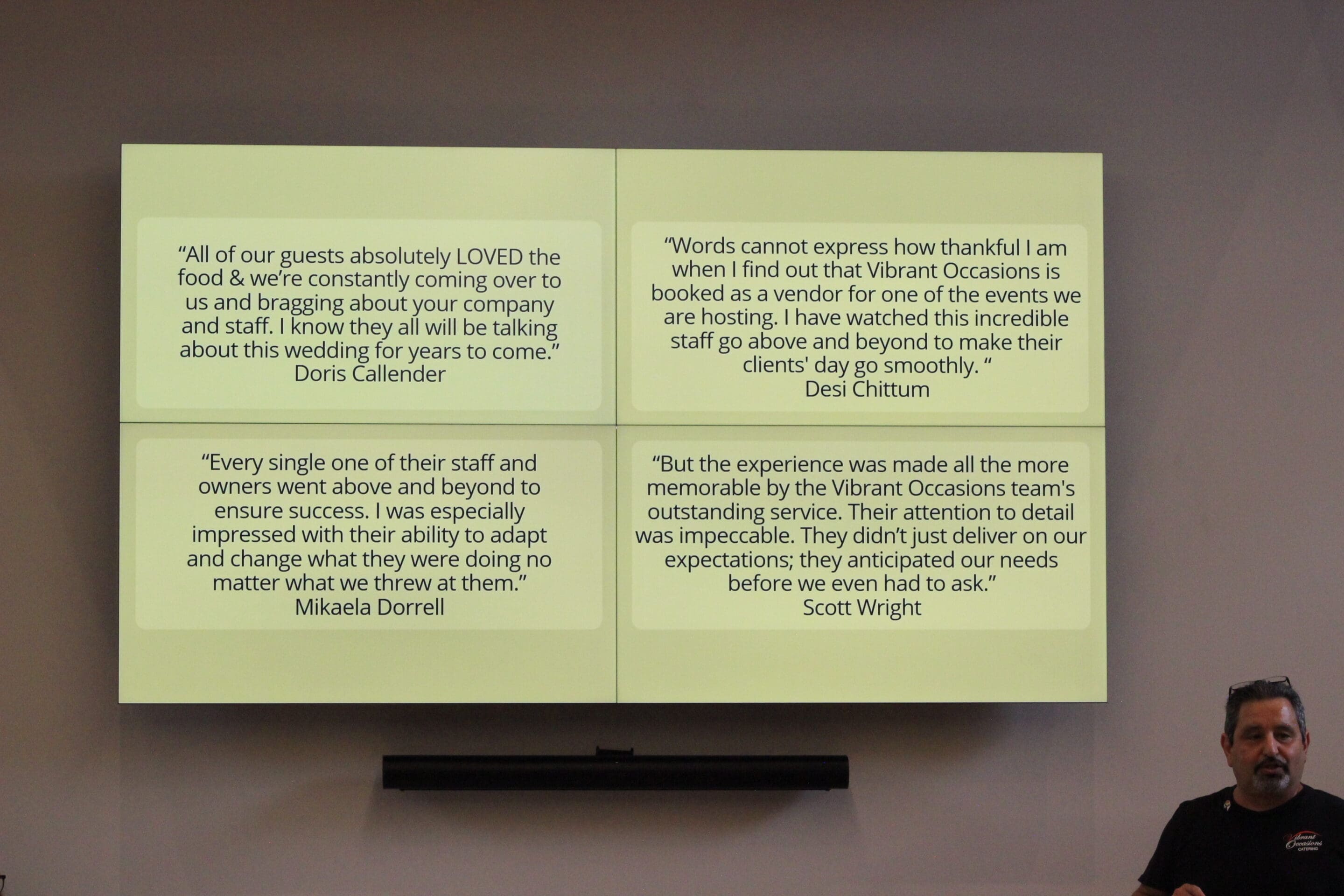 Best Caterer in Arkansas A man stands in front of a screen displaying four positive customer testimonials about Vibrant Occasions, praising their food, service, attention to detail, and adaptability during events.