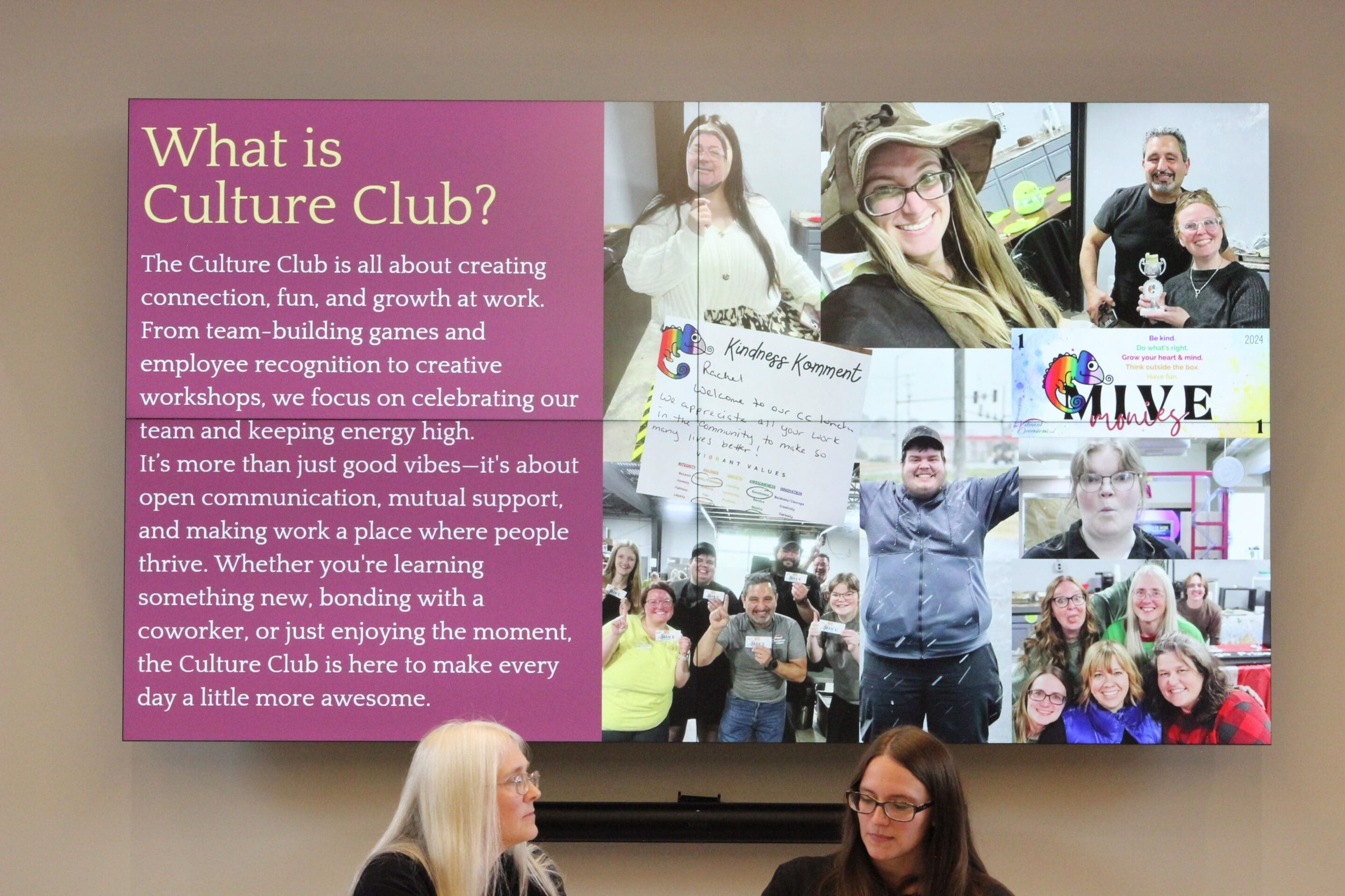 What is a Culture Club A display screen reads What is Culture Club? with a description and a collage of smiling people at events. Below, two women sit and talk at a table, facing the audience.
